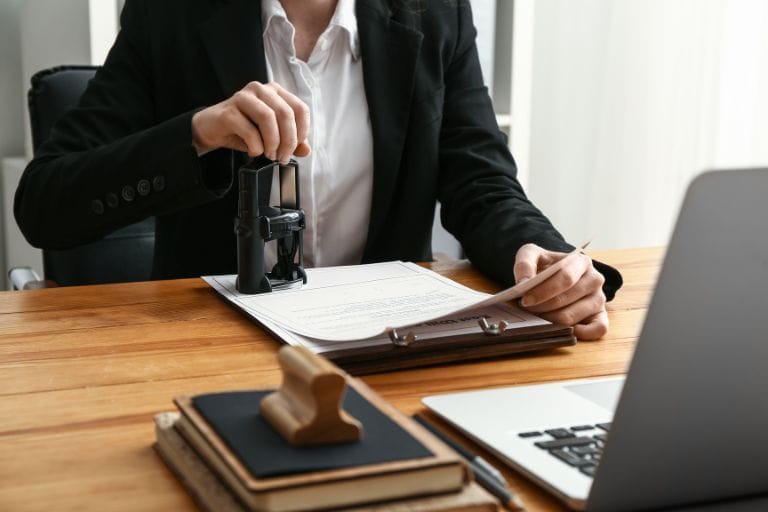 Traductor jurado poniendo un sello legal a un documento traducido.