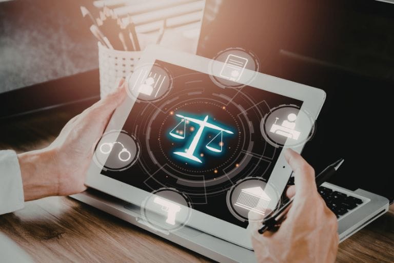 Manos sosteniendo una tablet con iconos de justicia y una balanza digital, representando servicios de traducción legal y jurídica para organismos gubernamentales y el sector público.
